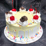 Drip cake with crushed Oreo cookies, colorful sprinkles, and cherries on top.